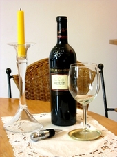 Weinflasche, Kerze und Weinglas auf dem Tisch